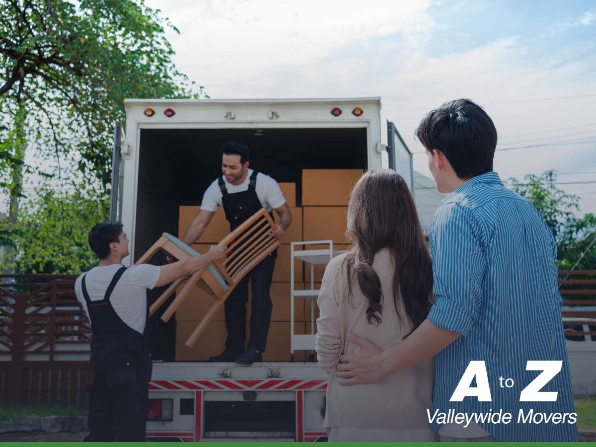 Professional moving companies loading furniture and boxes into a truck as a couple watches – A to Z Valleywide Movers